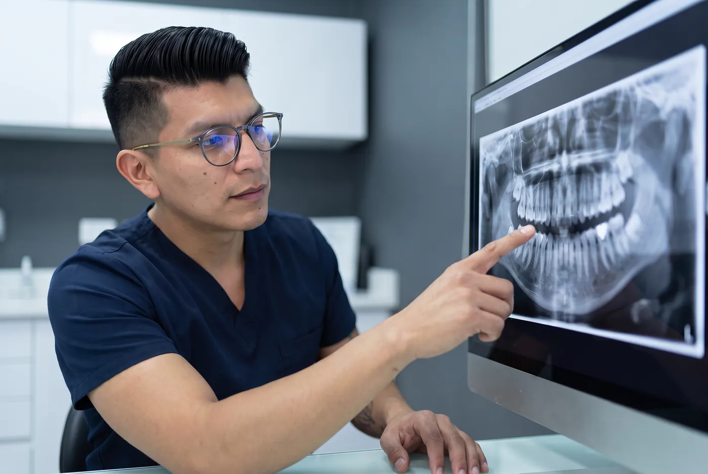 El Dr. Coral señalando una radiografía panorámica en el monitor